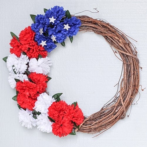 Learn how to make a red white and blue wreath for under $5 and 10 minutes using dollar store supplies. This easy American flag wreath makes the perfect DIY patriotic wreath for your front door!