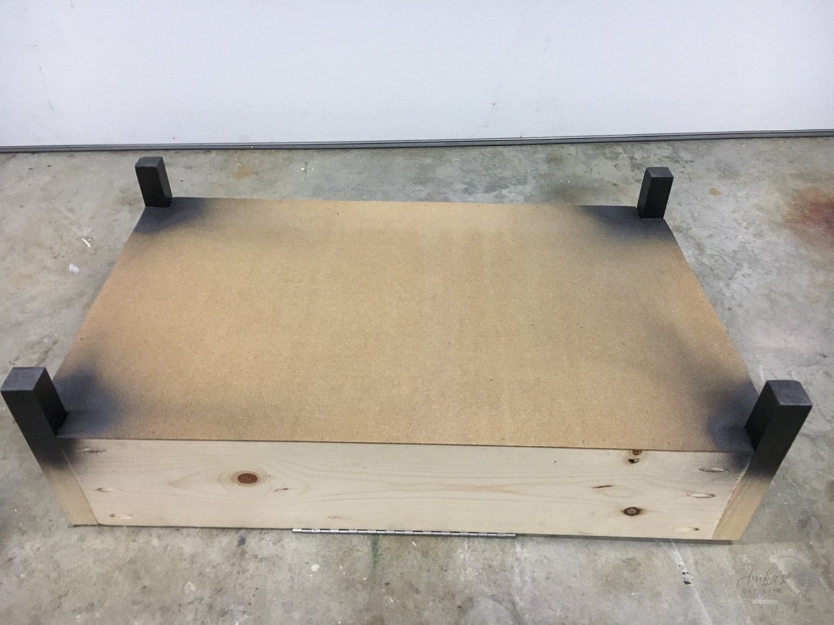 legs of the storage ottoman painted dark