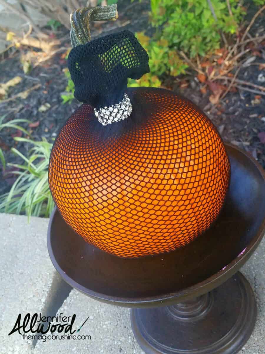 Orange pumpkin covered with a fishnet stocking