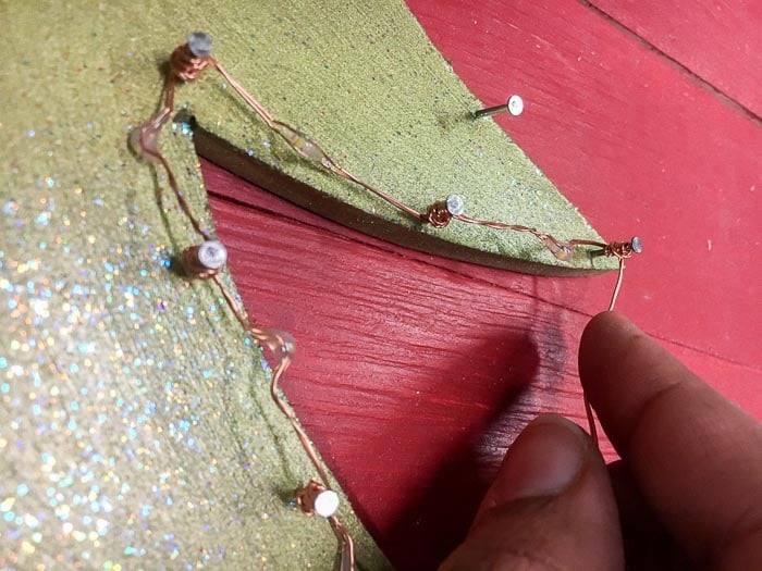 stringing LEDs on the DIY Christmas wall decoration