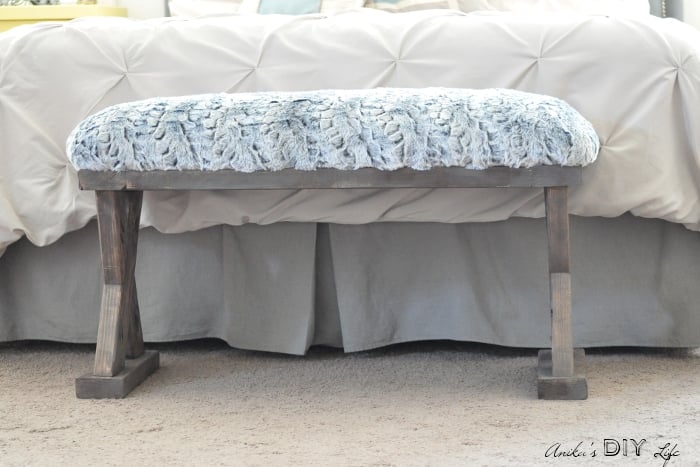 DIY bench with upholstered top at the end of a bed