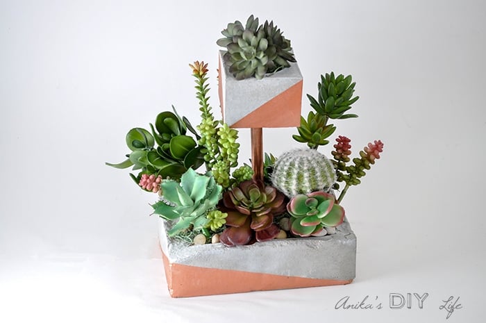 The perfect industrial touch for your home. DIY tiered concrete planter with copper pipe and paint