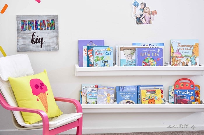 DIY Rain gutter bookshelves filled with books in a colorful playroom