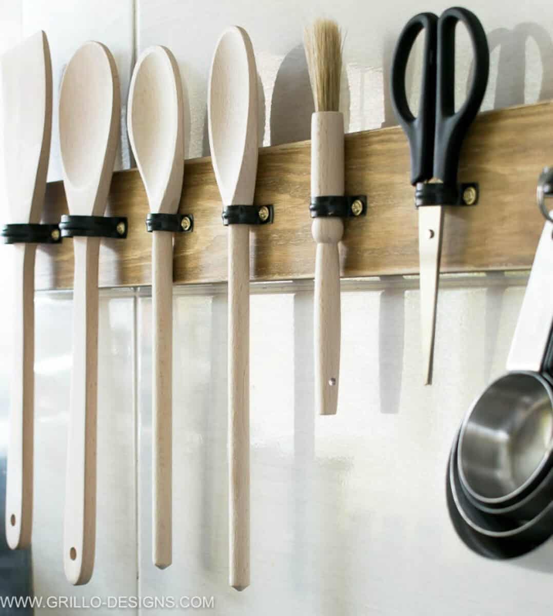 Board mounted on the wall as a utensil holder with wooden utensils