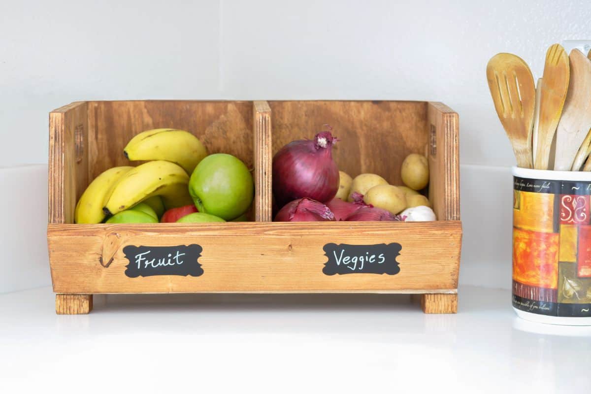 DIY wood storage bin with dividers storing fruits and vegetables