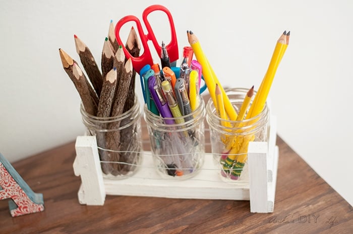Mason jar with wood and wire holder on desk with pencils