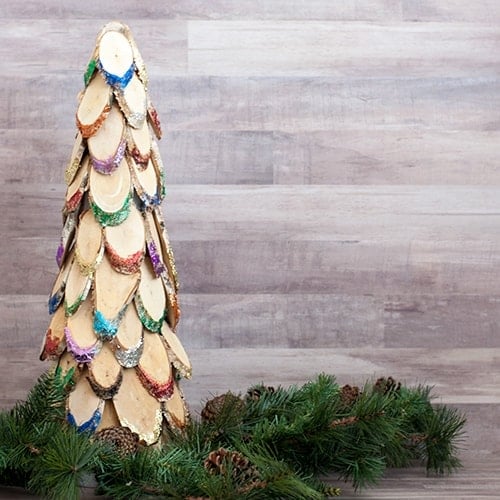 This colorful wood slice Christmas tree is the perfect DIY wooden Christmas decoration. Add lots of bright sparkle to your mantle or doorstep!