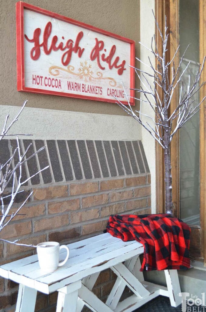 Wood sleigh ride sign hanging on porch