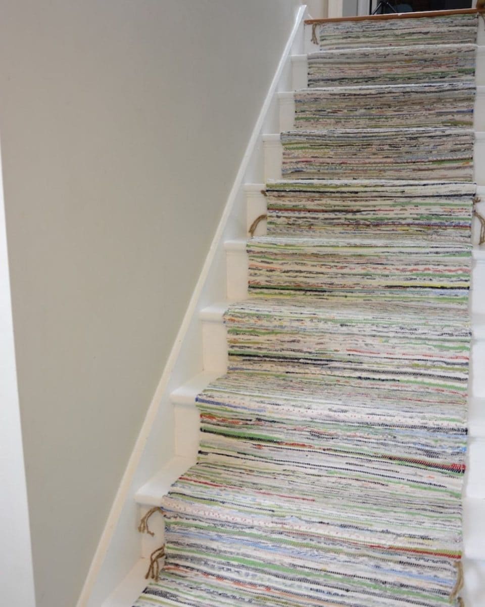 White painted stairs with Ikea rugs as a rug runner