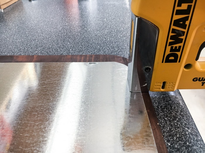 Attaching metal sheet to cutting board frame with a staple gun