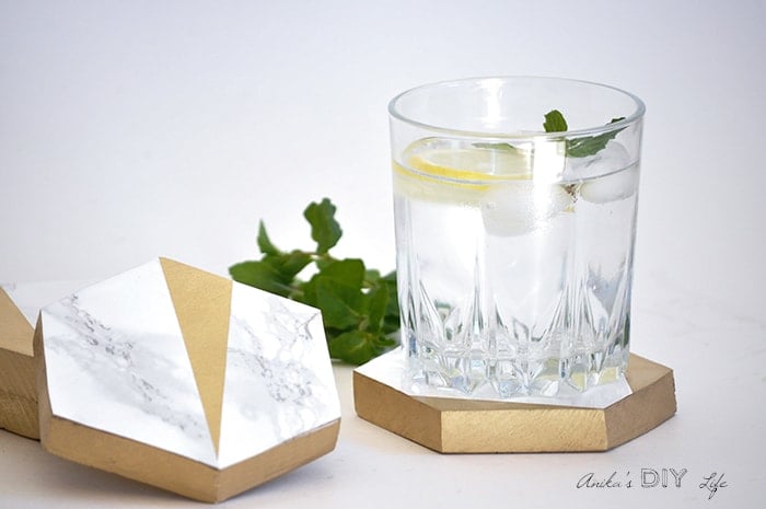 DIY hexagonal marble and gold coasters with a glass of water