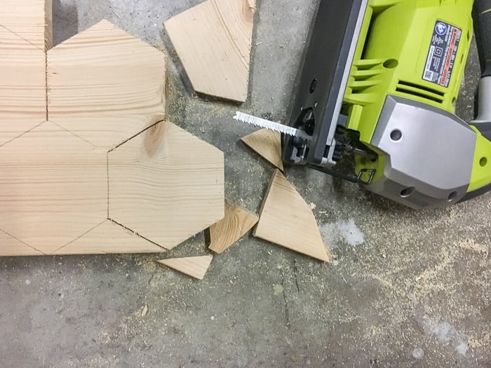 Hexagons cut out from scrap wood using a jigsaw for DIY hexagonal marble and gold coasters