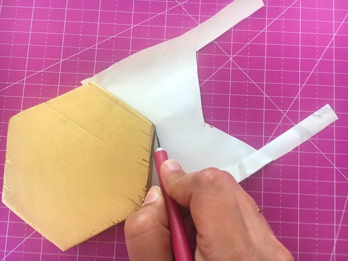 cutting off extra contact paper from the DIY hexagonal marble and gold coaster using an X-acto knife
