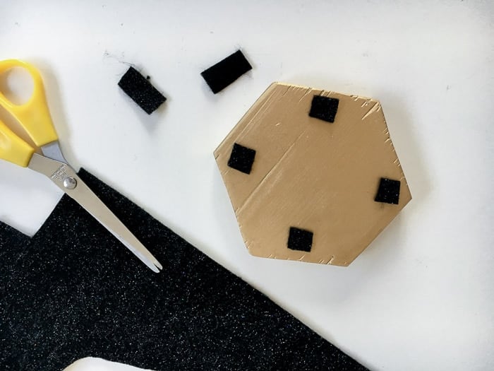 adding felt pads to the bottom of the DIY hexagonal marble and gold coasters