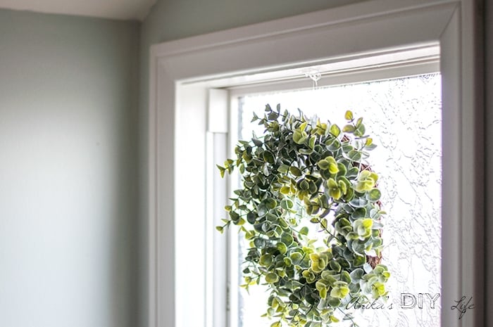 faux boxwood wreath form in bathroom window