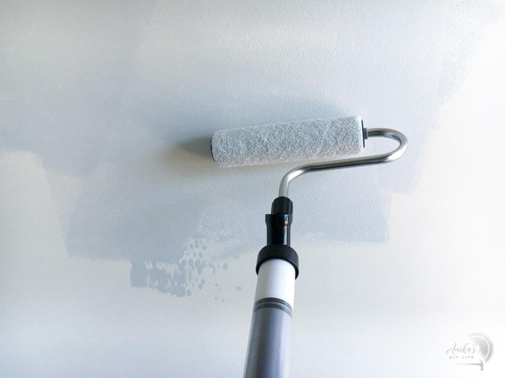 Rolling paint on the wall with the paintstick