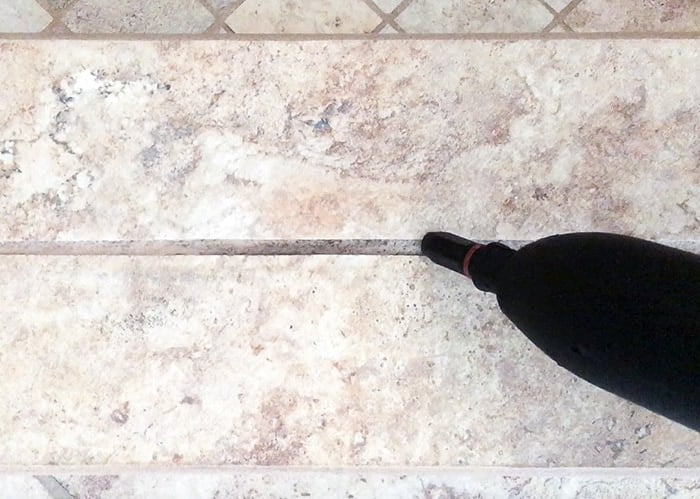 Cleaning the grout with steam cleaner