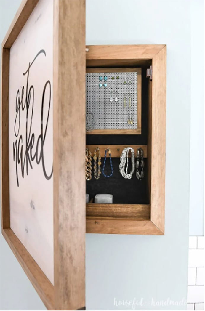 wooden jewelry organizer hanging on wall with door open