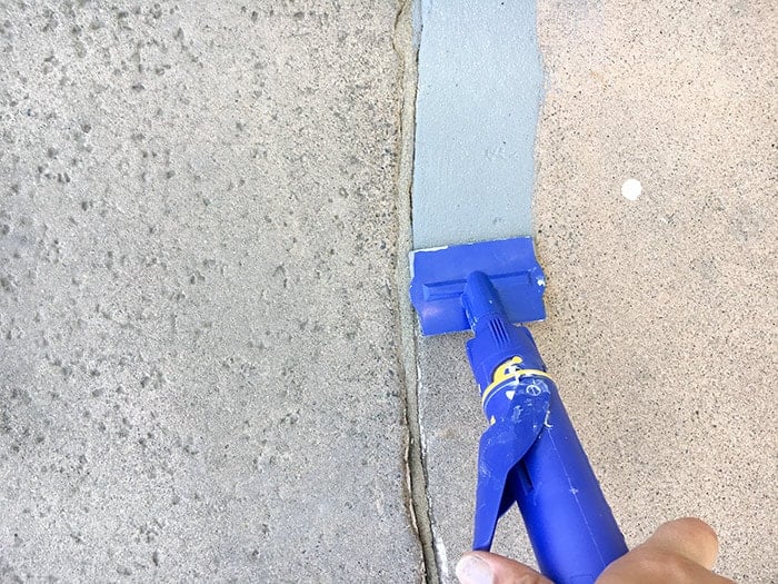 Cutting in the concrete edges using a quick painter | HomeRight Quick Painter review
