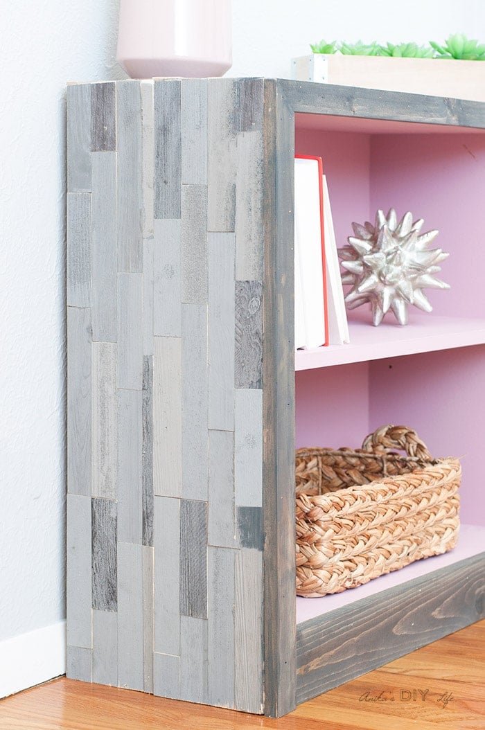 Pink and grey laminate oak bookshelf makeover - the after. Interior is pink and the outside with grey peel and stick barn wood tile.