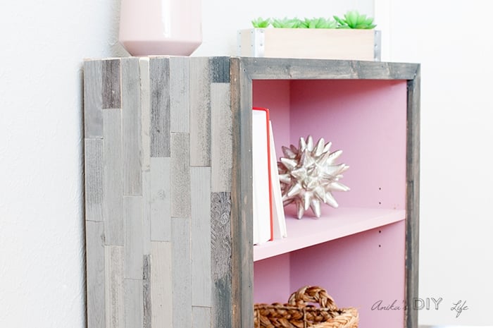 laminate bookshelf makeover with grey barn wood tile on the outside.