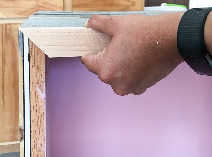 Attaching trim to the DIY weathered barn wood bookshelf