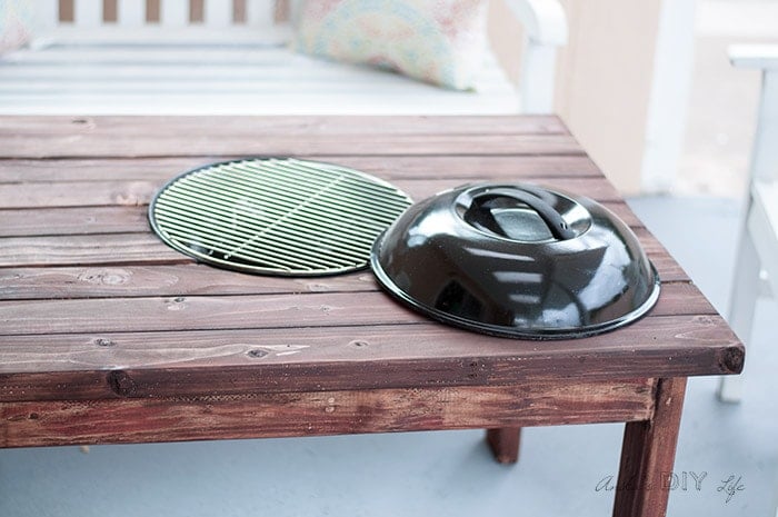 DIY patio table with fire pit open with grill attachment to cook on.