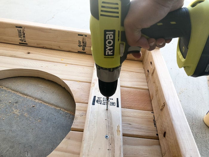 Attaching supports to the bottom of the DIY grill table for the patio