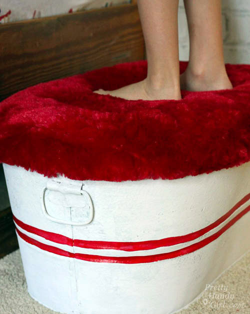 Galvanized tub with red fur top cushion.