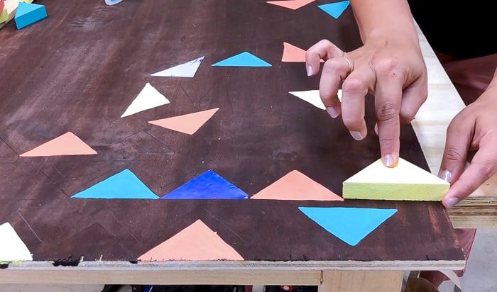 Glueing wood triangles to the large scale DIY wood wall art