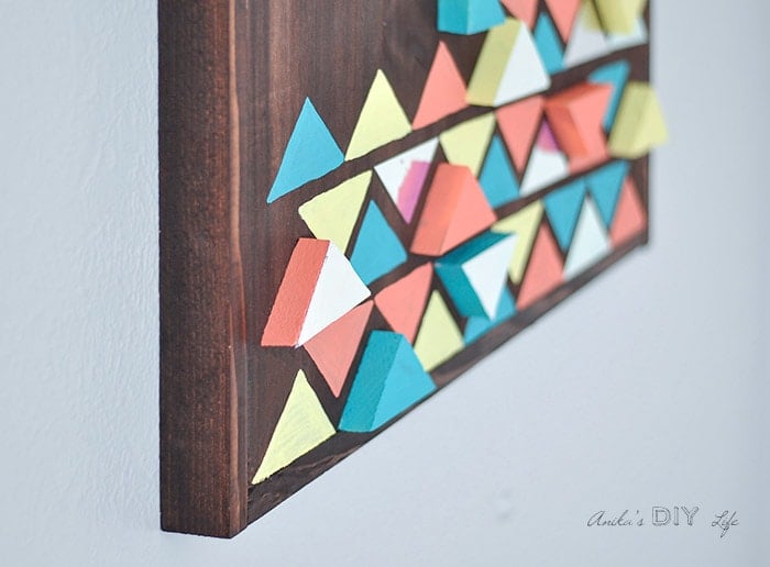 Close up angle of DIY wood wall art with colorful 3-dimension scrap wood triangles and Mirror Tape.