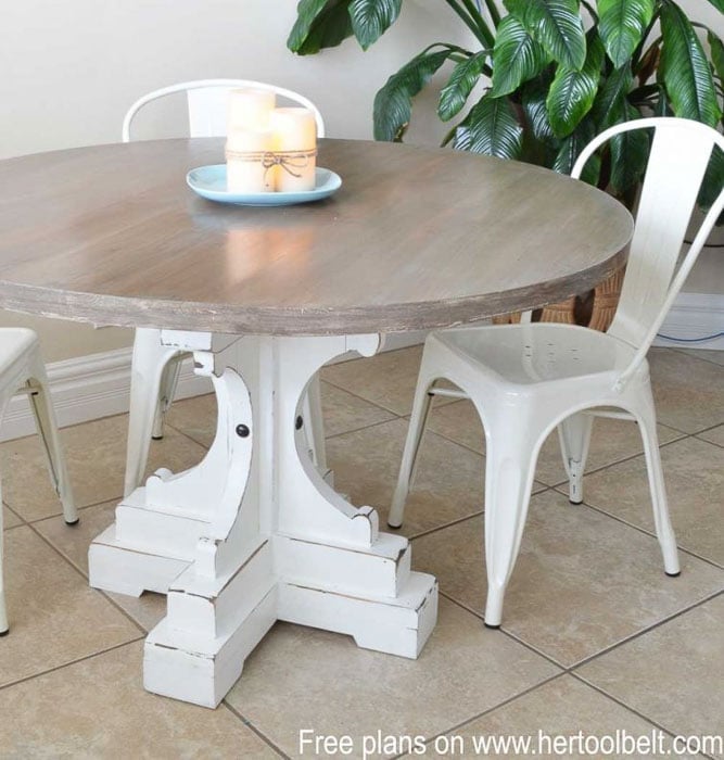 Round farmhouse table with pedestal feet and white chair