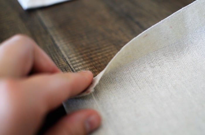 folding fabric on hem tape to make no-sew drop cloth curtains