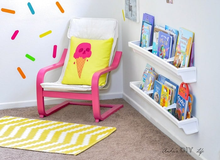 Rain gutter bookshelves in kids playroom filled with books.