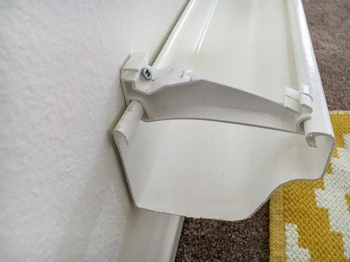 How to slide a rain gutter onto the hanger to make a rain gutter bookshelf.