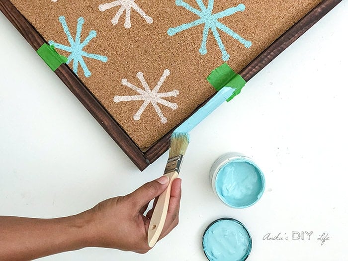 Painting edges of the cork bulletin board with craft paint