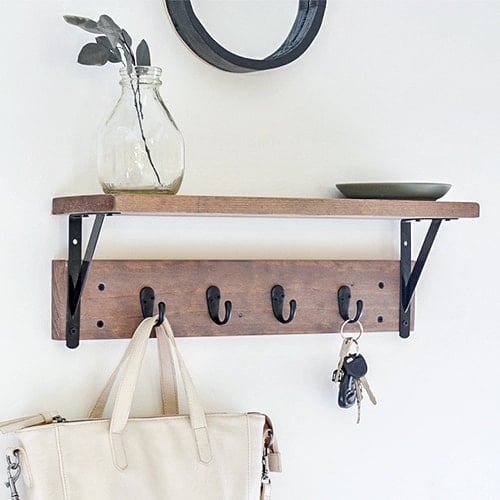 How to build your own DIY entryway shelf with hooks underneath. This easy to build entryway shelf is perfect for organization and makes great wall decor too!