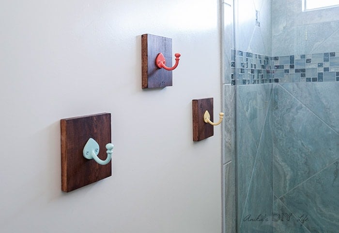 Colorful hooks on wood plaques in bathroom