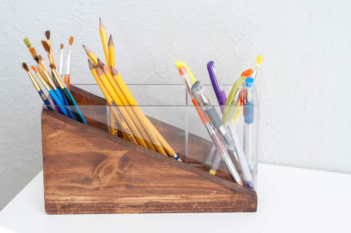 modern pencil holder made from scrap wood and acrylic with pens, pencils and craft brushes