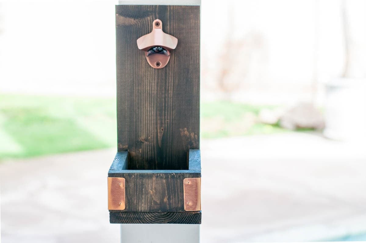 Outdoor wall mounted bottle opener on post on patio