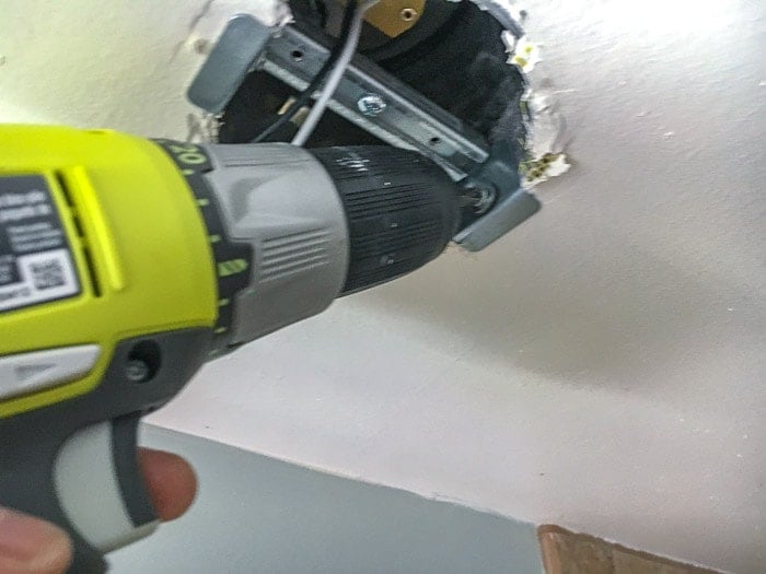 Attaching crossbar to the metal can using metal screws to replace can light with pendant