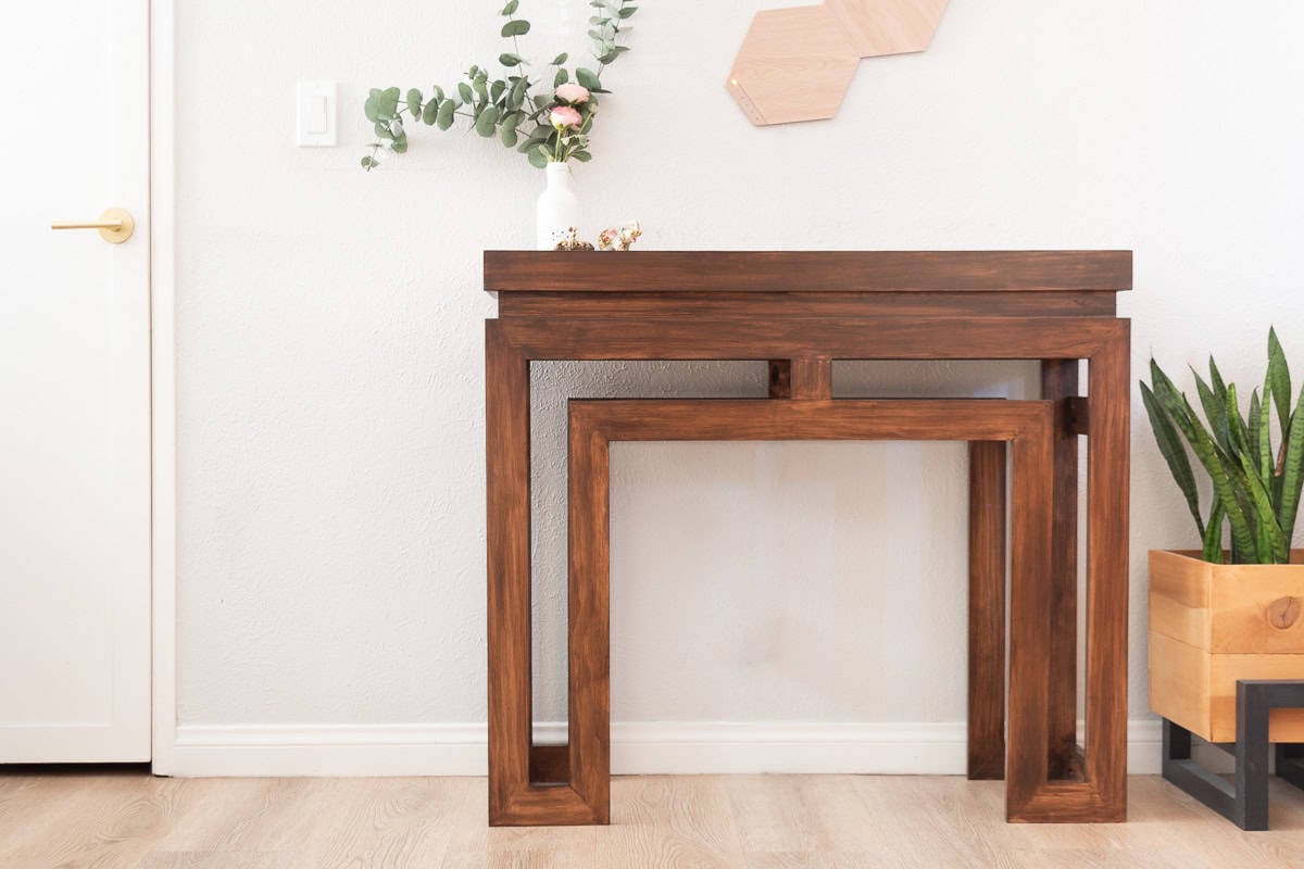 Brown Modern DIY console table in front of gray wall next to plants