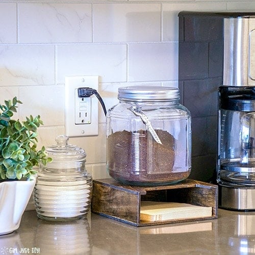 Coffee Filter Holder next to coffee pot topped with coffee canister.