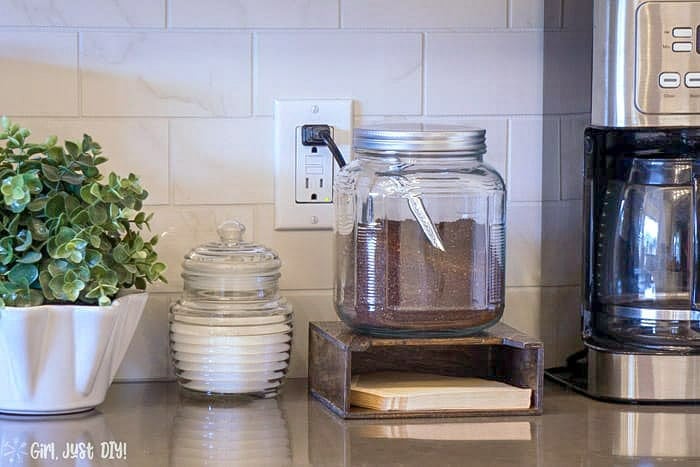 Coffee Filter Holder next to coffee pot topped with coffee canister.