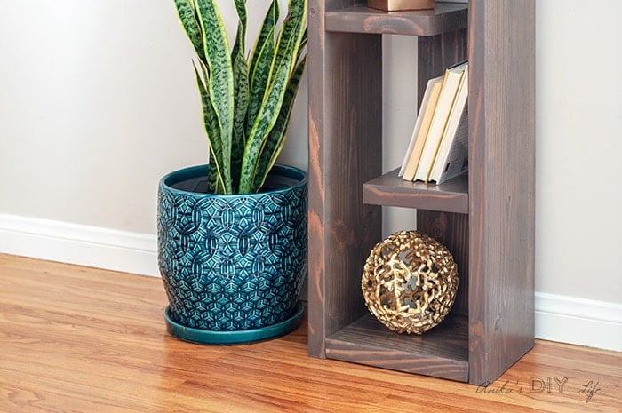 Close up of bottom of DIY modern bookshelf with decor items.