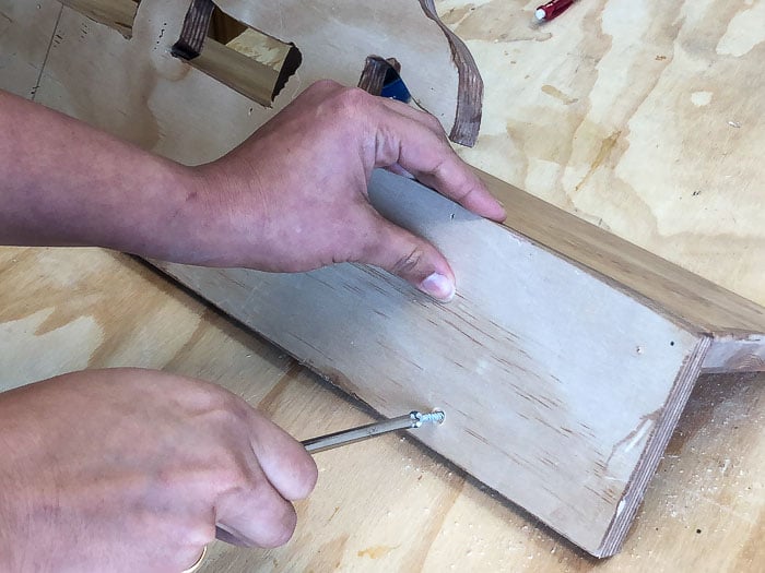 Attaching dinosaur hooks to the DIY Dinosaur shelf