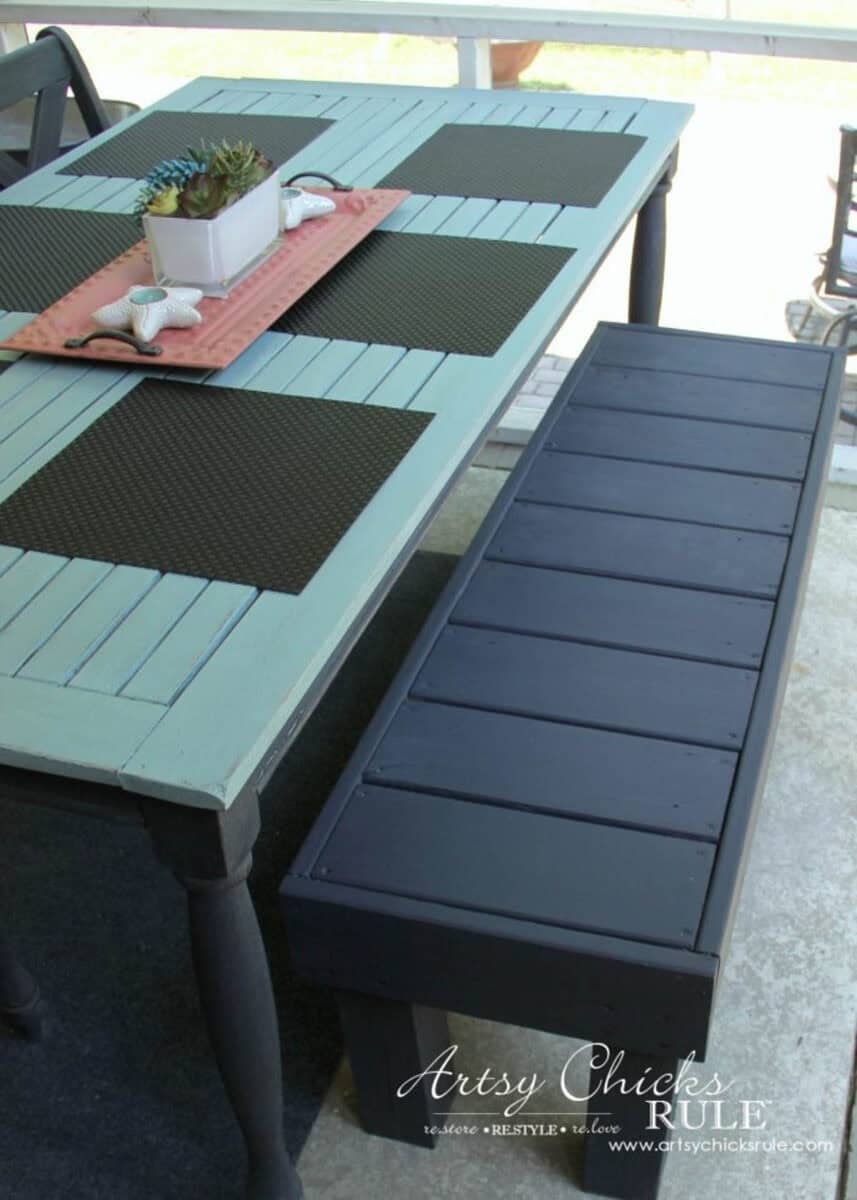 Blue painted outdoor bench next to an outdoor dining table