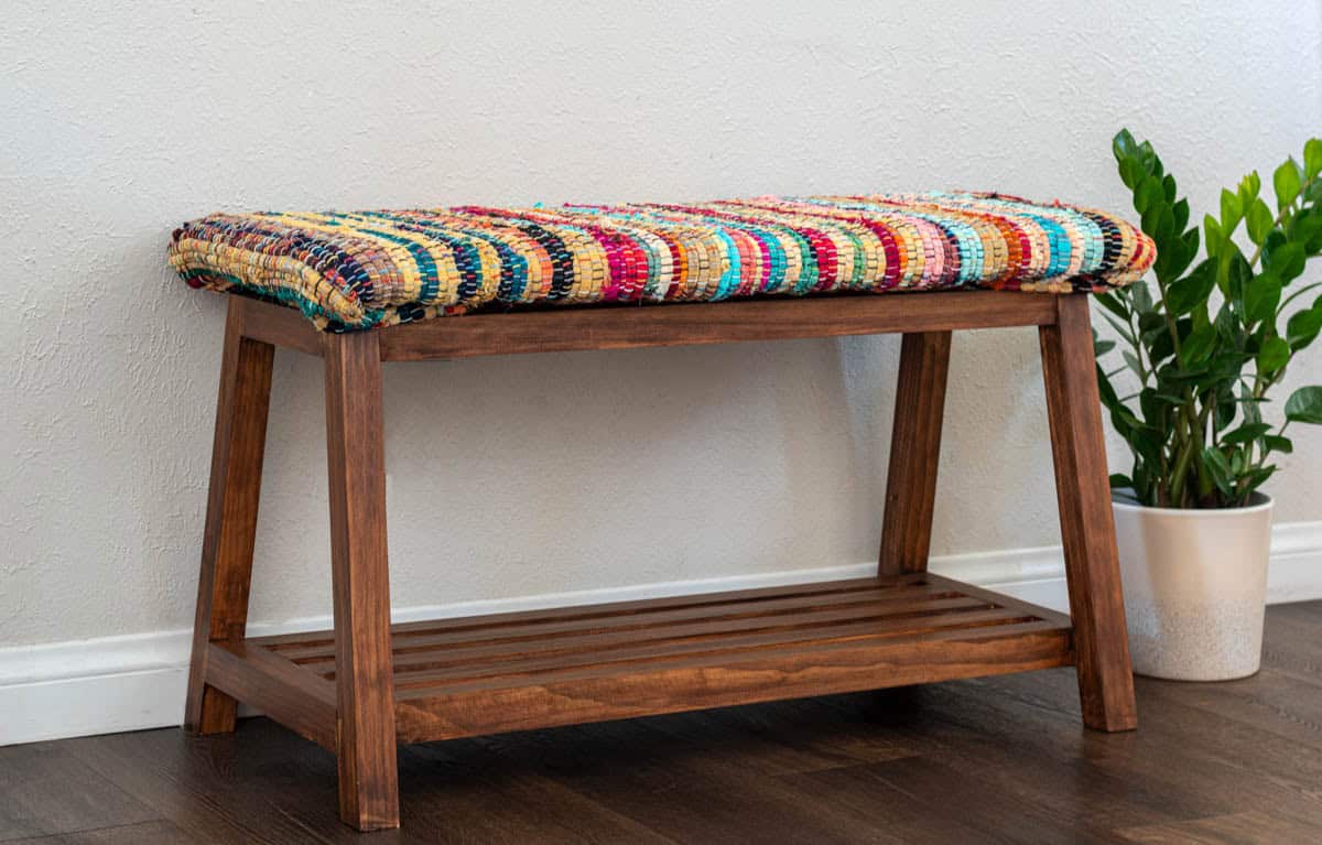 A frame DIY bench idea with colorful upholstered top and shoe storage shelf underneath