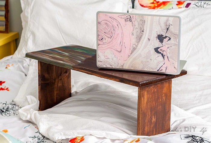 Simple DIY lap desk with legs on bed with computer on top
