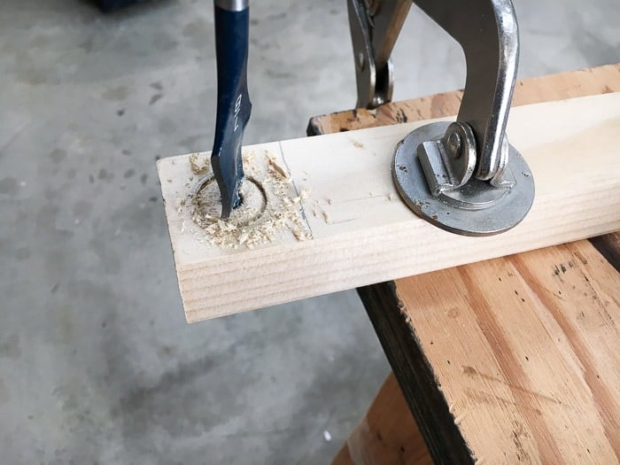 Making a hole in the 2x2 using a spade bit for the test tube